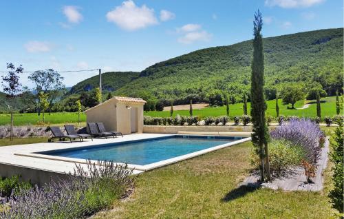 une piscine au milieu d'un jardin avec des montagnes en arrière-plan dans l'établissement Combemont, à Souspierre