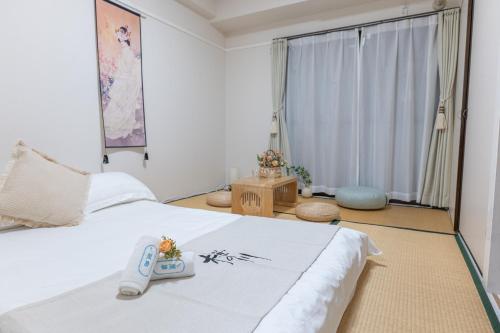 een slaapkamer met een bed met een afstandsbediening bij 桜の川6 Asakusa 704 Skytree bus 1 min,free wifi,cook,24 hours convenience in Tokyo