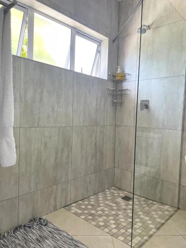 a shower with a glass door in a bathroom at Muthaiga House in Margate