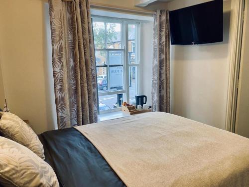 um quarto com uma cama grande e uma janela em Blue Bell em Rothwell