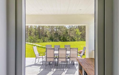 a glass door leading to a patio with a table and chairs at 3 Bedroom Cozy Home In Gotlands Tofta in Tofta