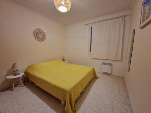 une chambre avec un lit jaune et une fenêtre dans l'établissement Maison avec jardin et terrasses à Cavalaire, calme et équipements modernes - FR-1-100-323, à Cavalaire-sur-Mer