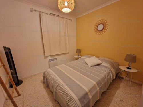 une chambre avec un lit et un miroir au mur dans l'établissement Maison avec jardin et terrasses à Cavalaire, calme et équipements modernes - FR-1-100-323, à Cavalaire-sur-Mer