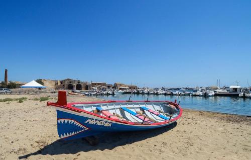 a boat sitting on the sand on the beach at 2 Bedroom Amazing Home In Noto in Noto