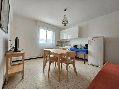 une cuisine avec une table, des chaises et un réfrigérateur dans l'établissement Appartement lumineux à 150m de la plage avec WiFi - 4 personnes - Animaux sur demande - FR-1-476-218, à La Faute-sur-Mer