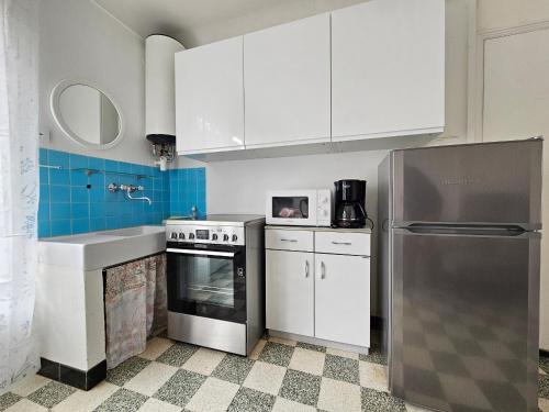 La cuisine est équipée de placards blancs, d'une cuisinière et d'un évier. dans l'établissement Appartement 5min Plage, Balcon, Animaux OK sur Demande, Parking - La Faute-sur-Mer - FR-1-476-219, à La Faute-sur-Mer