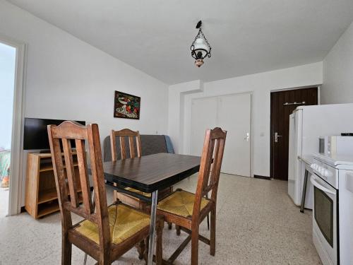 d'une salle à manger avec une table, des chaises et un réfrigérateur. dans l'établissement Appartement Proche Plage avec Parking, Wi-Fi et Animaux Acceptés sur Demande - La Faute-sur-Mer - FR-1-476-221, à La Faute-sur-Mer