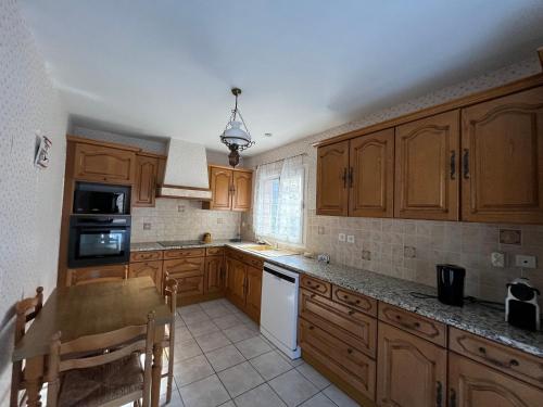 une cuisine avec des placards en bois et un appareil blanc dans l'établissement Maison T3 à Arcachon, proche plage et centre, 2 chambres, terrasse avec BBQ - FR-1-319-551, à Arcachon