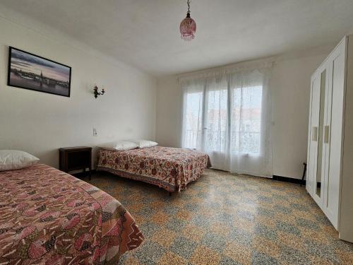 une chambre d'hôtel avec deux lits et une fenêtre dans l'établissement Appartement cosy avec balcon, plage à 150m, parking, animaux sur demande - La Faute-sur-Mer - FR-1-476-220, à La Faute-sur-Mer