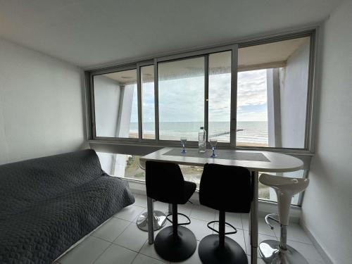 - une chambre avec une table et des chaises devant une fenêtre dans l'établissement Studio confortable avec balcon et lave-linge à Saint-Jean-de-Monts - FR-1-224C-302, à Saint-Jean-de-Monts