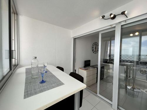 - une table blanche avec une bouteille et des verres dans l'établissement Studio confortable avec balcon et lave-linge à Saint-Jean-de-Monts - FR-1-224C-302, à Saint-Jean-de-Monts