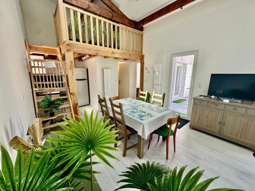 une salle à manger avec une table et une télévision dans l'établissement Maison lumineuse au cœur d'Arcachon, plage à 200m, terrasse privée ! - FR-1-420-148, à Arcachon
