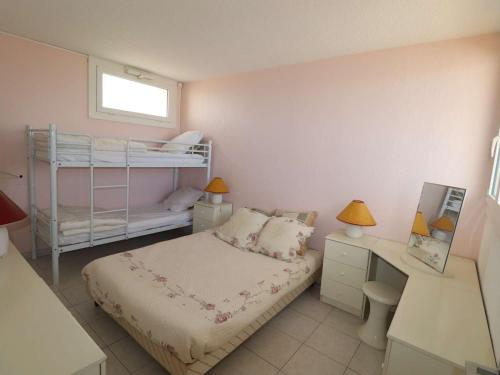 - une petite chambre avec des lits superposés et un bureau dans l'établissement Marina 2 pièces avec terrasse et parking, animaux admis, proche plage - FR-1-307-260, au Grau-du-Roi