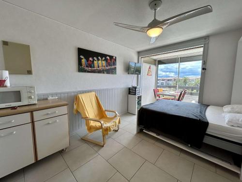 - une chambre avec un lit, une télévision et un four micro-ondes dans l'établissement Studio/Cabine, 4 Couchages, Piscine, Parking, Proche Plage, St Cyprien - FR-1-225D-211, à Saint-Cyprien