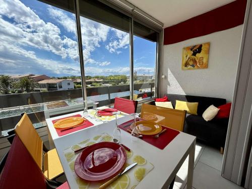 une salle à manger avec une table et une grande fenêtre dans l'établissement Studio/Cabine, 4 Couchages, Piscine, Parking, Proche Plage, St Cyprien - FR-1-225D-211, à Saint-Cyprien