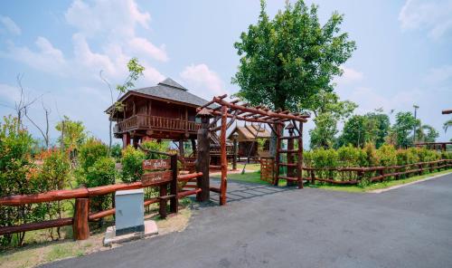 a wooden pavilion with a wooden fence and a tree at Tayama Farm Khaoyai in Nakhon Ratchasima
