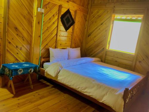 ein Schlafzimmer mit einem Bett und einem Fenster in einer Hütte in der Unterkunft Lysa House in Lào Cai