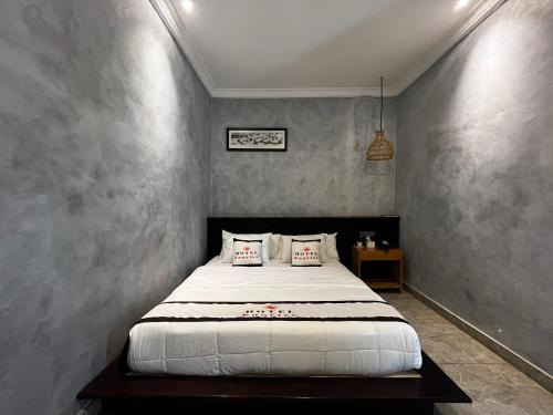 a bedroom with a white bed in a room at SUNRISE HOTEL LABUAN BAJO in Labuan Bajo