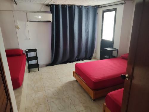 a small room with two beds and a window at Ender's house in San Andrés