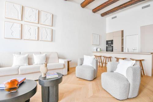 un salon avec des meubles blancs et une table dans l'établissement Le Marcel - Appart standing 3 ch avec clim, à Marseille