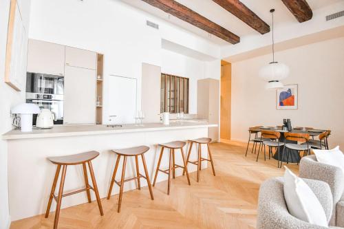 - une cuisine et un salon avec un bar et des tabourets dans l'établissement Le Marcel - Appart standing 3 ch avec clim, à Marseille