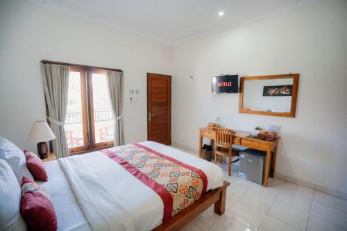 a bedroom with a bed and a desk with a window at Kayuma House Canggu in Canggu