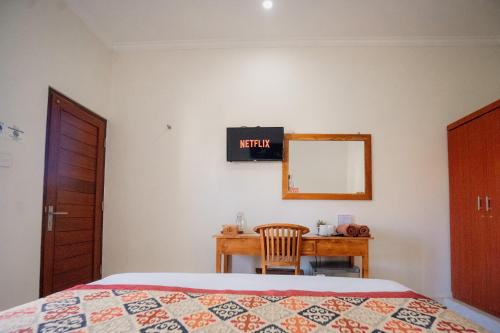 a bedroom with a bed and a desk and a mirror at Kayuma House Canggu in Canggu