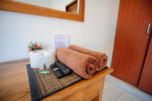a towel and a remote control on a table at Kayuma House Canggu in Canggu