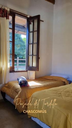 查斯科穆斯的住宿－Tordillo B&B，一间卧室设有两张床和窗户。