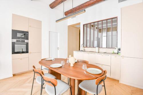 une cuisine avec une table et des chaises en bois dans l'établissement Le Paul - Appart de standing avec 2 ch et clim, à Marseille