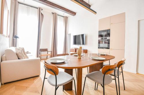 un salon avec une table et des chaises en bois dans l'établissement Le Paul - Appart de standing avec 2 ch et clim, à Marseille