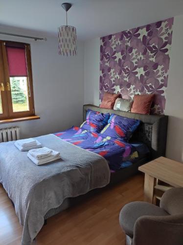 sypialnia z łóżkiem i fioletową ścianą w obiekcie Komfortowe mieszkanie w Busku Zdroju