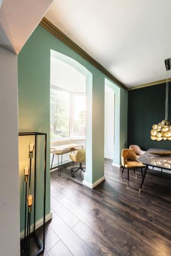 a living room with green walls and a table and chairs at STADtPERLE in Itzehoe