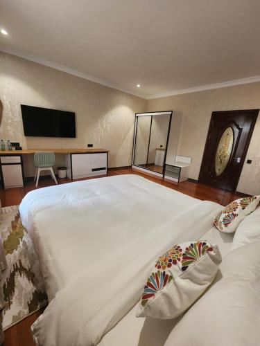 a large white bed with two pillows in a bedroom at HOTEL DEHLAVI o in Dushanbe