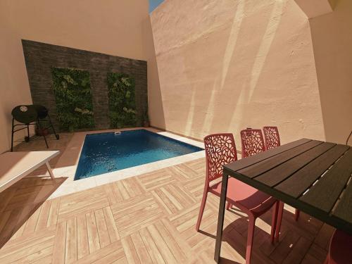 a swimming pool in a room with a table and chairs at Ramla Valley Vista in Nadur with Private Pool in Nadur