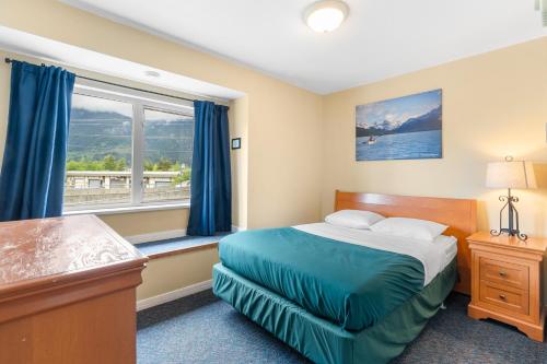 a bedroom with a bed and a window at Squamish Adventure Inn in Squamish