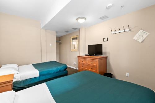 a hotel room with two beds and a tv at Squamish Adventure Inn in Squamish