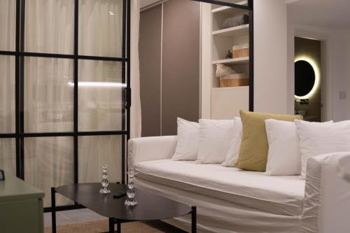 a living room with a white couch and a table at Vizion Juncal- Encanto francés en el corazón de Recoleta- Wifi alta velocidad-Seguridad 24 horas in Buenos Aires