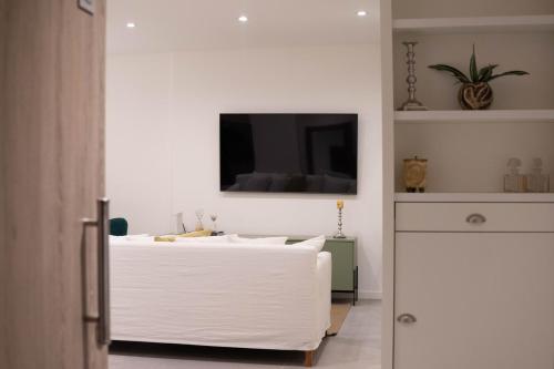 a bedroom with a white bed and a tv on the wall at Vizion Juncal- Encanto francés en el corazón de Recoleta- Wifi alta velocidad-Seguridad 24 horas in Buenos Aires