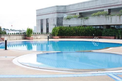 una grande piscina di fronte a un edificio di Thumrin Thana Hotel a Trang