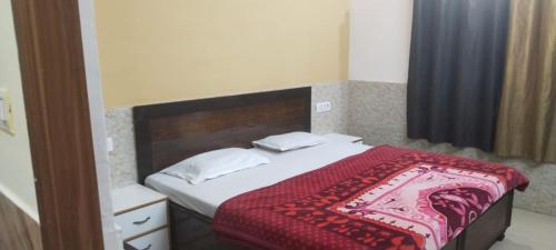 ein Schlafzimmer mit einem Bett mit einer roten Decke darauf in der Unterkunft Goroomgo Kunj Residency Mathura Near Bus Stand - Parking Facility & Restrurant in Mathura