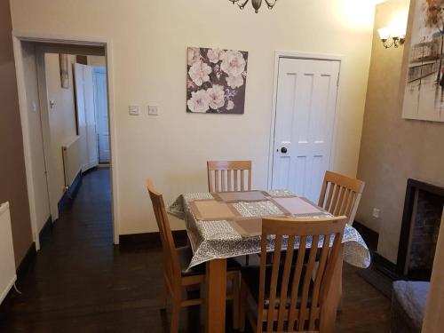 een eetkamer met een tafel en stoelen en een open haard bij Stay Norwich Apartments Pottergate in Norwich