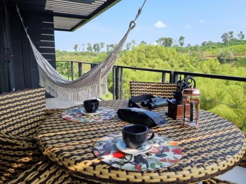 a table with two cups and plates on a balcony at Maranatha. Grotto & Boutique+Hydrotherapy in Pereira