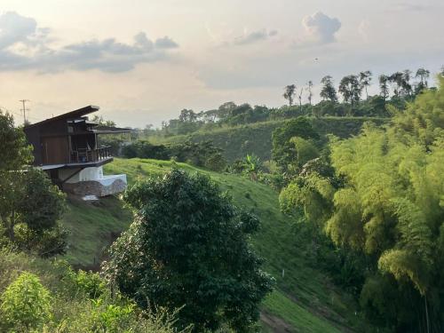 a house on the side of a hill with trees at Maranatha. Grotto & Boutique+Hydrotherapy in Pereira