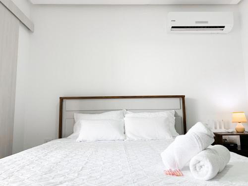 a bedroom with a bed with white sheets and pillows at Airbnb Guayaquil, Mall del Sol, Piso alto in Guayaquil