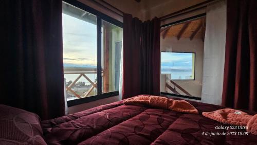 a bedroom with a bed and a window with a view at Ocho Cabañas in San Carlos de Bariloche