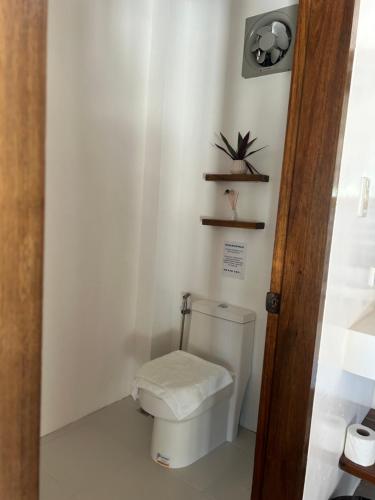 a bathroom with a toilet and a plant on the wall at Yapak Beach Villas in San Isidro