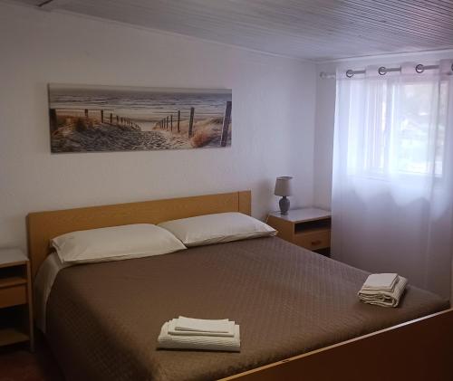 a bedroom with a bed with two towels on it at Andi in Stalettì