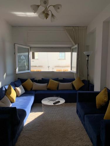 a living room with a blue couch with yellow pillows at Le pacha appart au cœur de Rabat in Rabat
