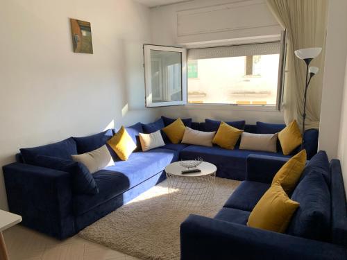 a living room with a blue couch and yellow pillows at Le pacha appart au cœur de Rabat in Rabat